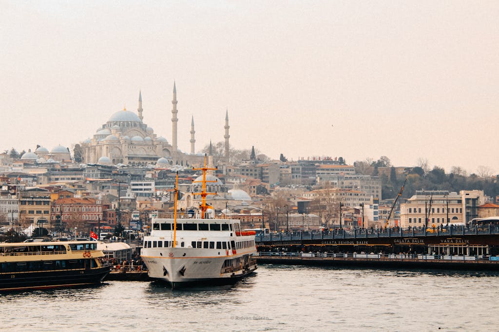 Scenic view of Istanbul skyline with ferries on the Bosphorus and Suleymaniye Mosque in the background.